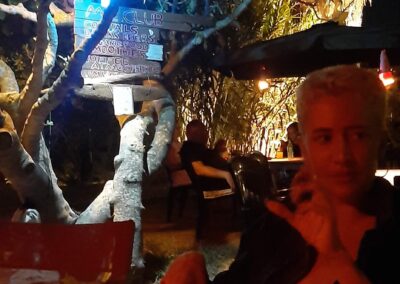 a girl in cowboy hats sitting at a table with drinks and talking to another man on the phone