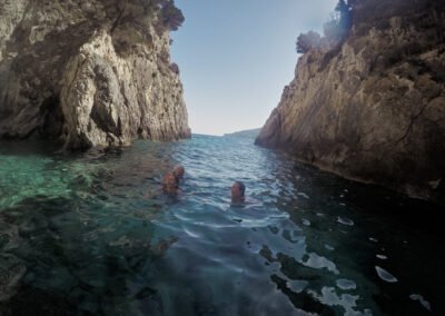 Three women gazing in wonder as the swim into a secret cave on a Zakynthos island boat tour.