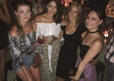 a group of girls posing for a photo on a nightclub