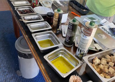 a Different angle of the same picture :A selection of Olive Oil from the Aristeon Olive press museum and people are tasting different kinds of oil as they have learnt the procedure in the methods. The Olive press uses.