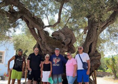 Happy Tourists that did this Private tour, sitting under the 2000 year old olive tree in Zakynthos