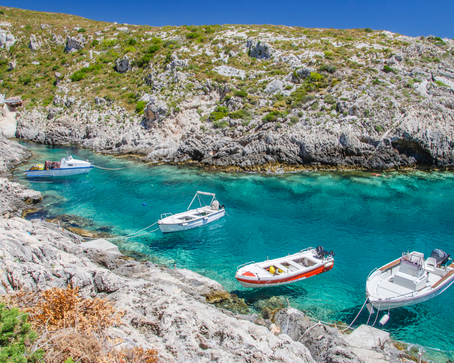 Porto Roxa Limnionas boats look like they are hovering over the clear waters of Zakynthos