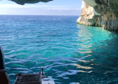The view from a boat looking out from the Blue Caves of Zakynthos island with aqua blue water.