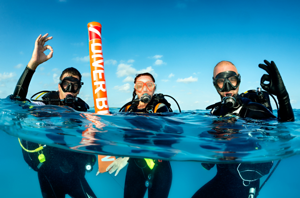 Group of friends on their scuba diving experience giving the perfect handsign
