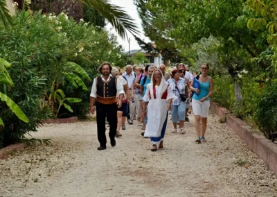 Guides in Therianos Organic Farm wearing traditional costumes, walking group of people inside the farm